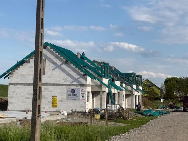 Cieśle montują impregnowaną więźbę dachową na kilku budynkach osiedla jednocześnie