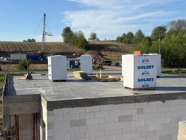 Strop nad parterem z dostarczonymi paletami bloczków z betonu komórkowego, gotowy pod murowanie ścian piętra