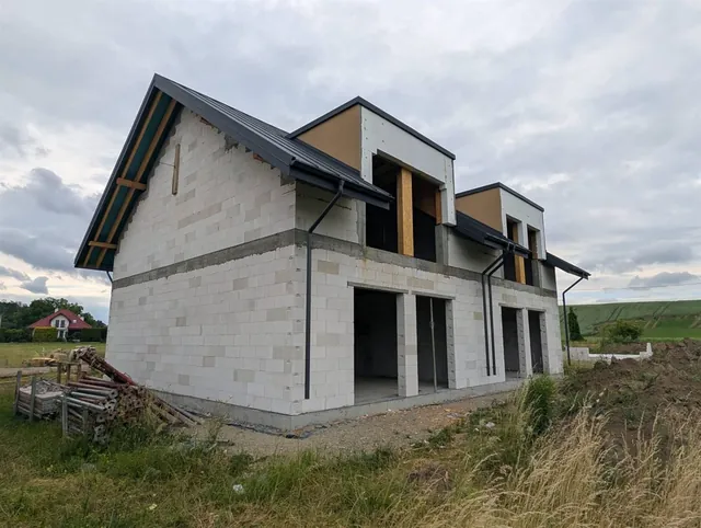 Budynek dwulokalowy z gotowym grafitowym dachem, lukarnami i otworami okiennymi bez stolarki