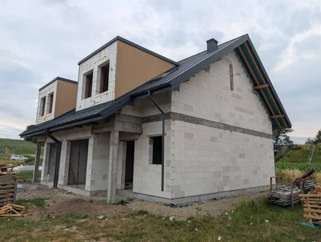 Elewacja frontowa z dwiema lukarnami, orynnowaniem i kominem nad gotową połacią dachu